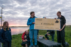 Jeppe neemt de cheque van Emiel in ontvangst